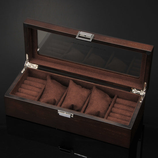 Une boîte à montres en bois Boites Lefiguet à quatre compartiments.