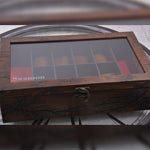Une boîte en bois Boites Lefiguet remplie de chocolats et d'une horloge.