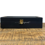 Une boîte à bijoux noire et dorée Boite de rangement pour montres 12 Slots sur une table en bois de Boites-lefiguet.com.