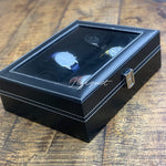 Un remontoir de montre Boîte à Montre Simili Cuir Noir 10 Slots avec trois montres Boites-lefiguet.com dedans.