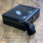 Une Boîte à Montre Simili Cuir Noir 10 Slots de Boites-lefiguet.com avec une montre à l'intérieur.