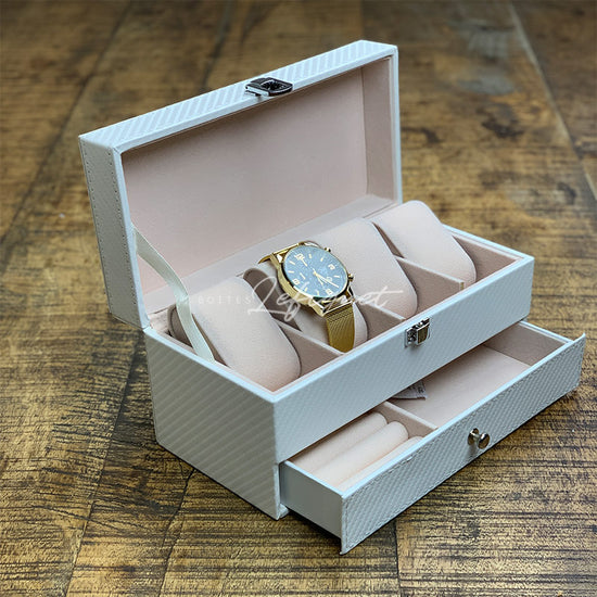 Une boîte à montre en cuir blanc avec une montre dorée de Boites-lefiguet.com à l'intérieur.