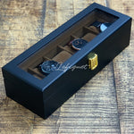 Une boîte noire Boite de rangement pour montres 6 Slots contenant quatre montres Boites-lefiguet.com.